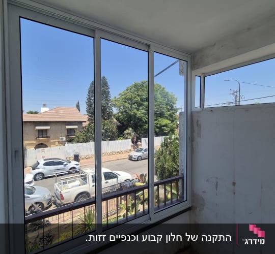 חלון אלומיניום עם נוף לרחוב ועצים